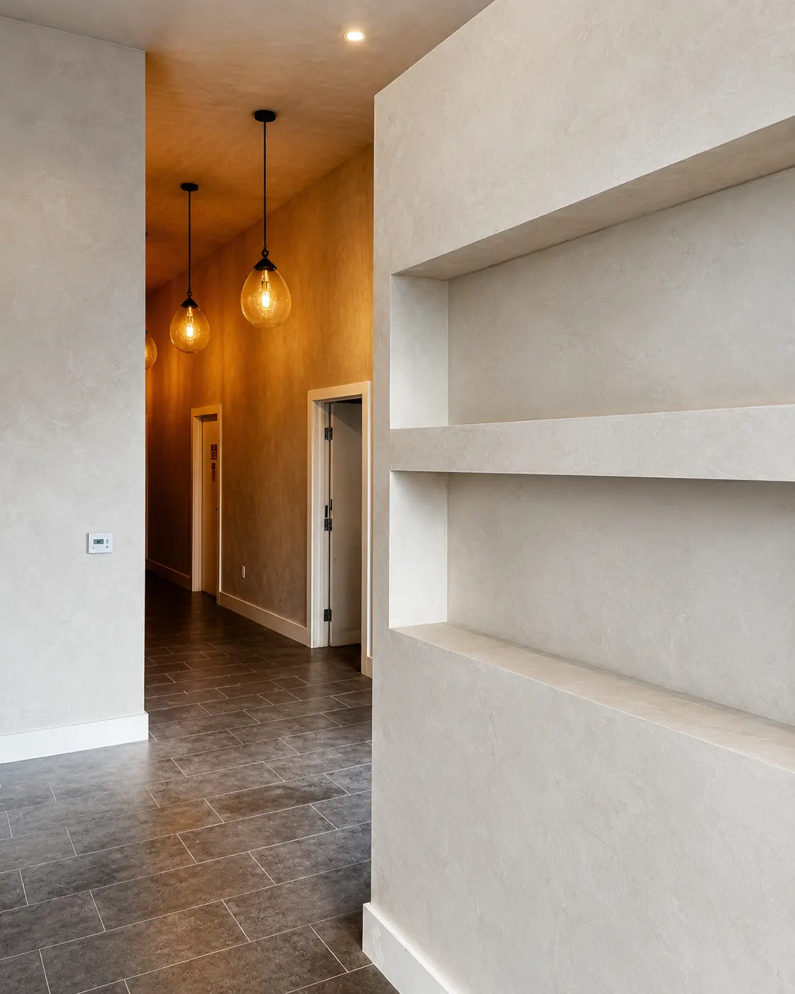 Lime wash walls with sculptural recessed niches along a corridor, in a Costa Mesa interior.