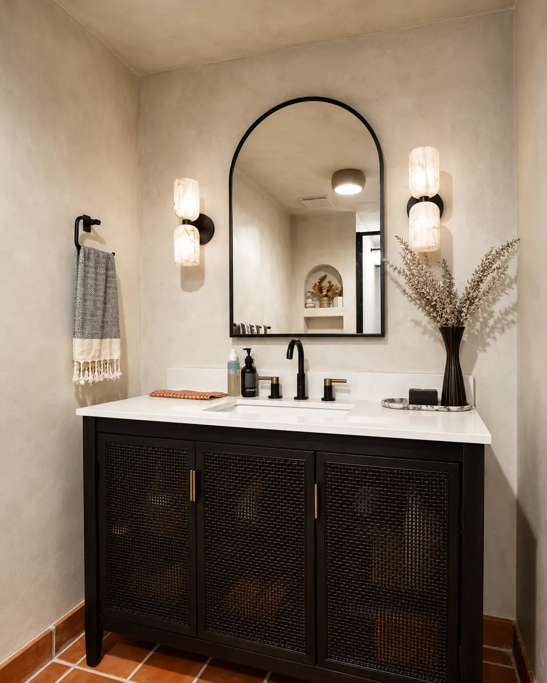 Lime wash walls in a powder room with an arched mirror and a dark vanity, in a Santa Ana project.