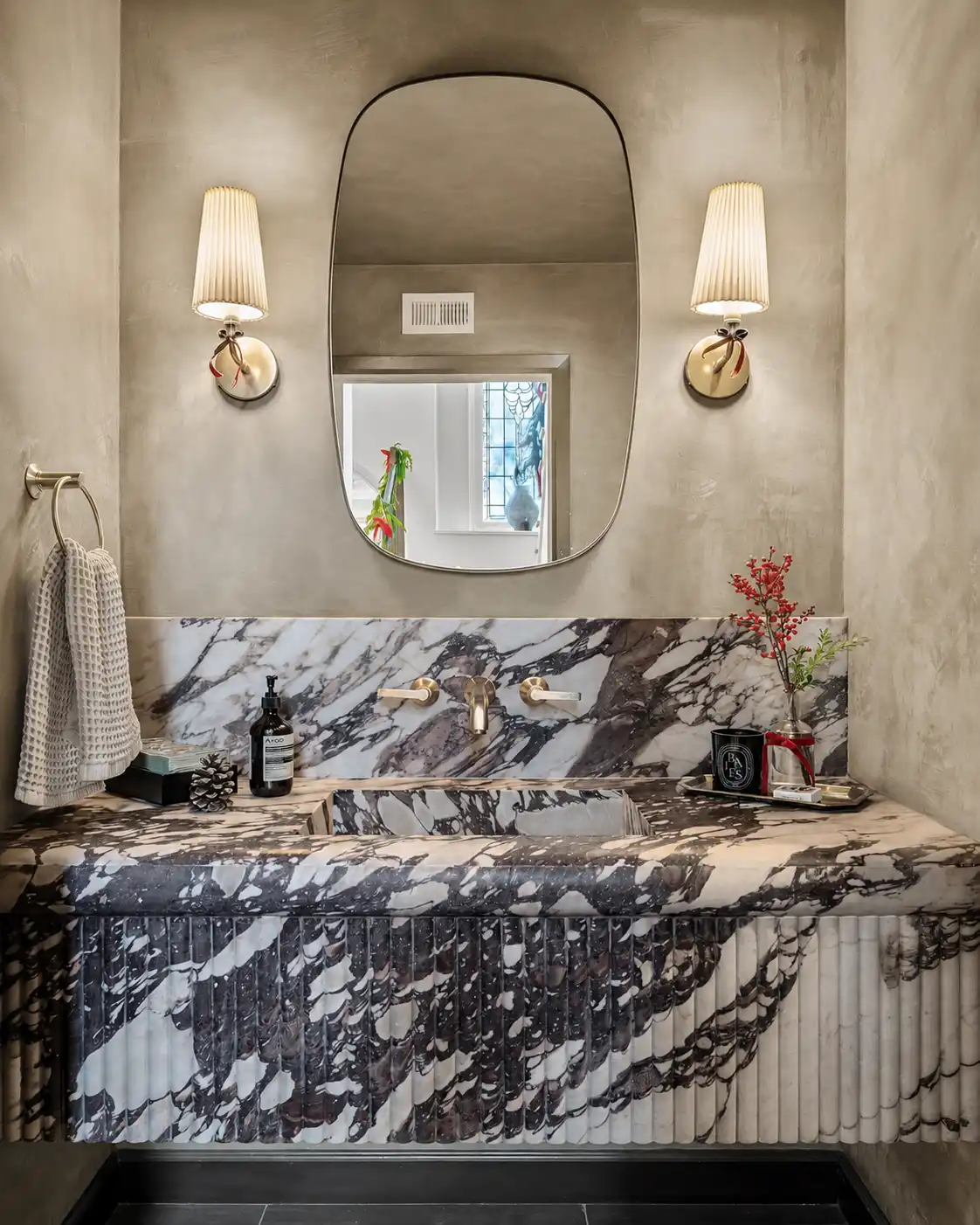 Soft greige matte Roman clay walls in a powder room with a marble vanity, away from direct wet zones, in a Laguna Beach project.