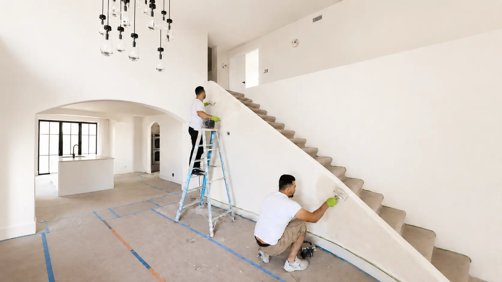 SBK in-house finish specialists hand-finishing a curved staircase wall in a Southern California home.