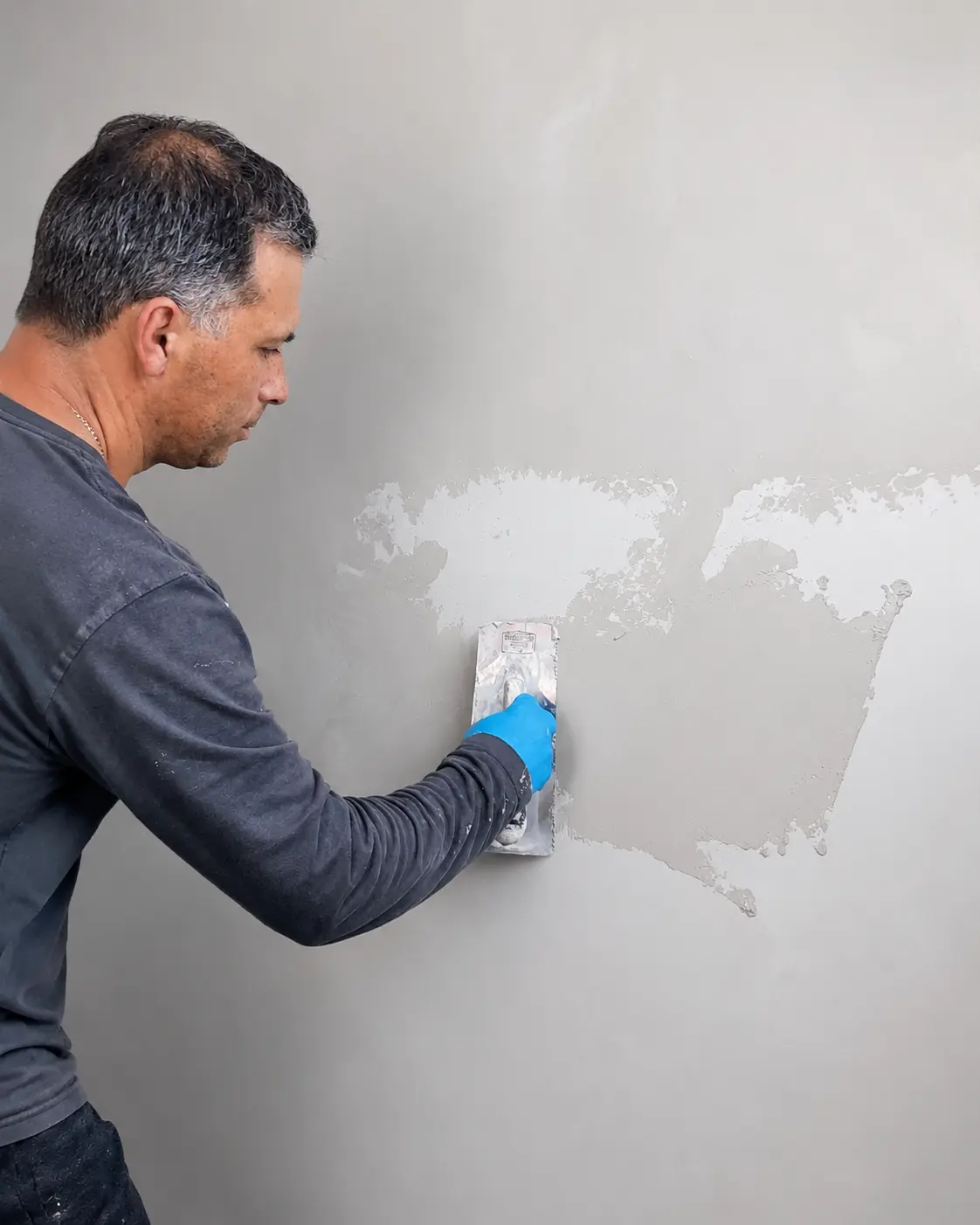 Igor Bakan applying a decorative finish by hand with a steel trowel.