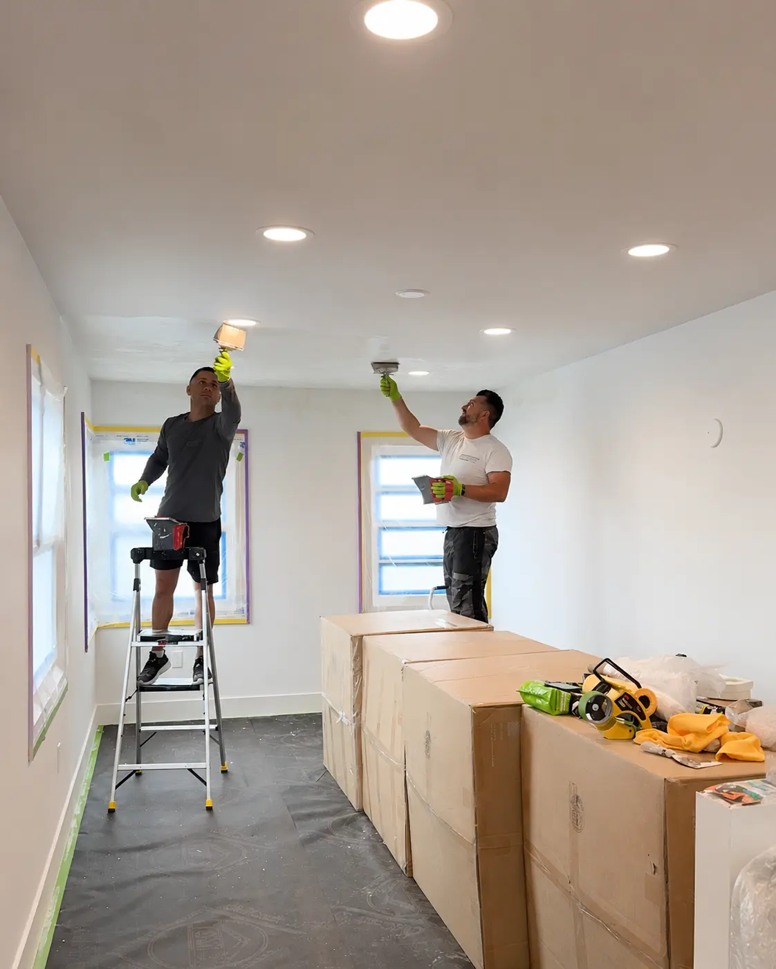 SBK specialists finishing a ceiling in an occupied home - windows masked and floors protected.
