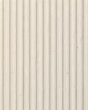 Fluted plaster texture sample with vertical ribbed channels in warm cream.