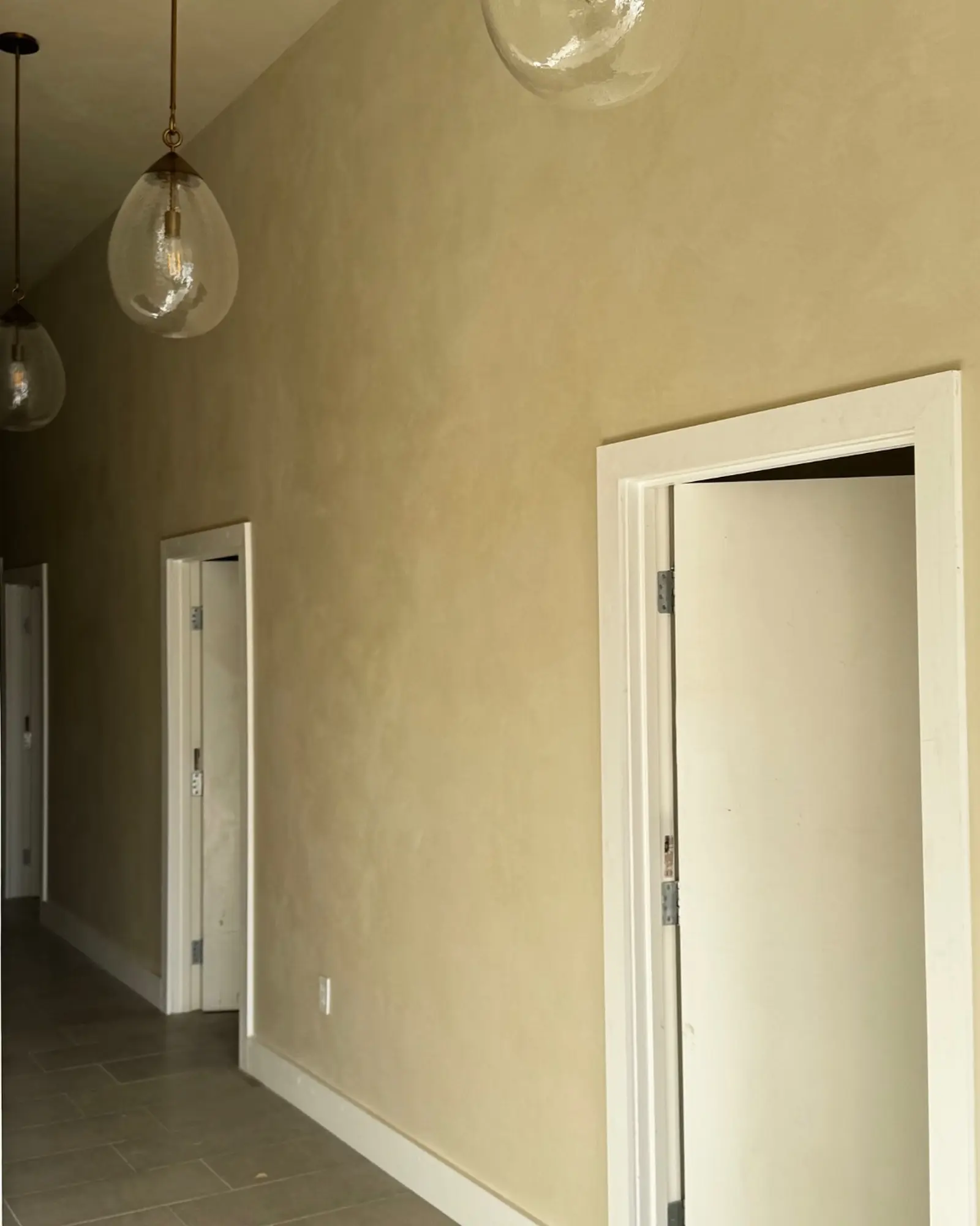 Lime wash corridor walls with treatment room doorways in a Costa Mesa med spa.