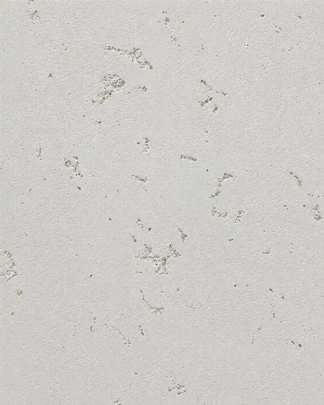 Real hand-applied polished stone-effect plaster sample in soft off-white, with a smooth travertine-like face and fine natural pitting.