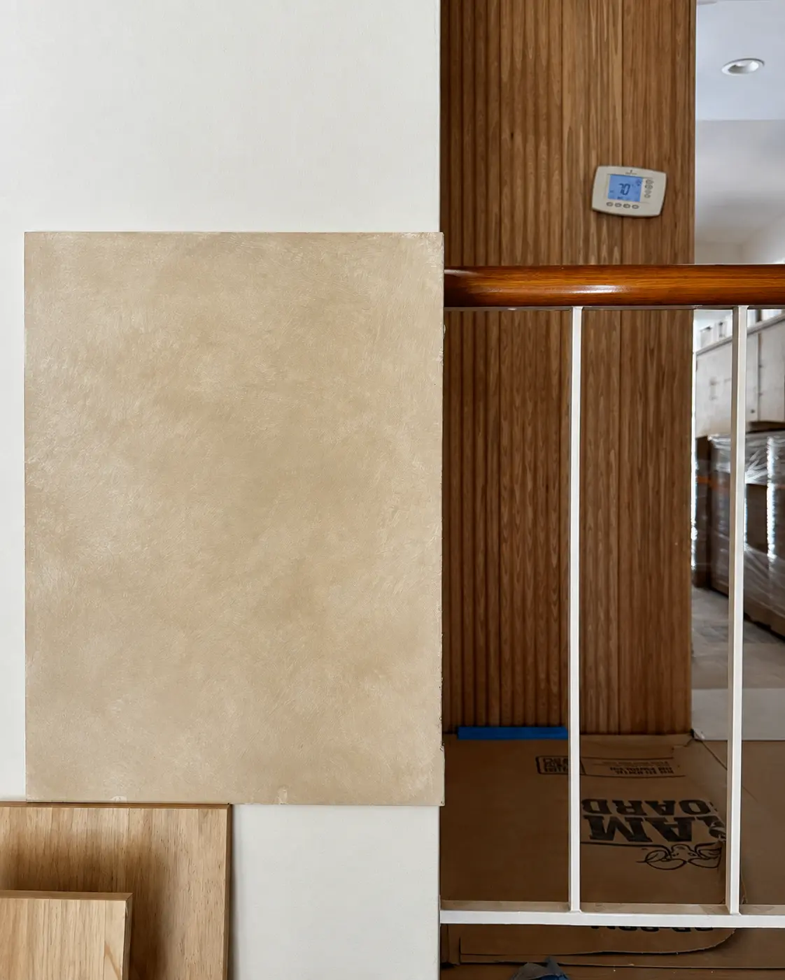 Approved lime wash sample board in a light warm coffee tone shown in the room's own light.