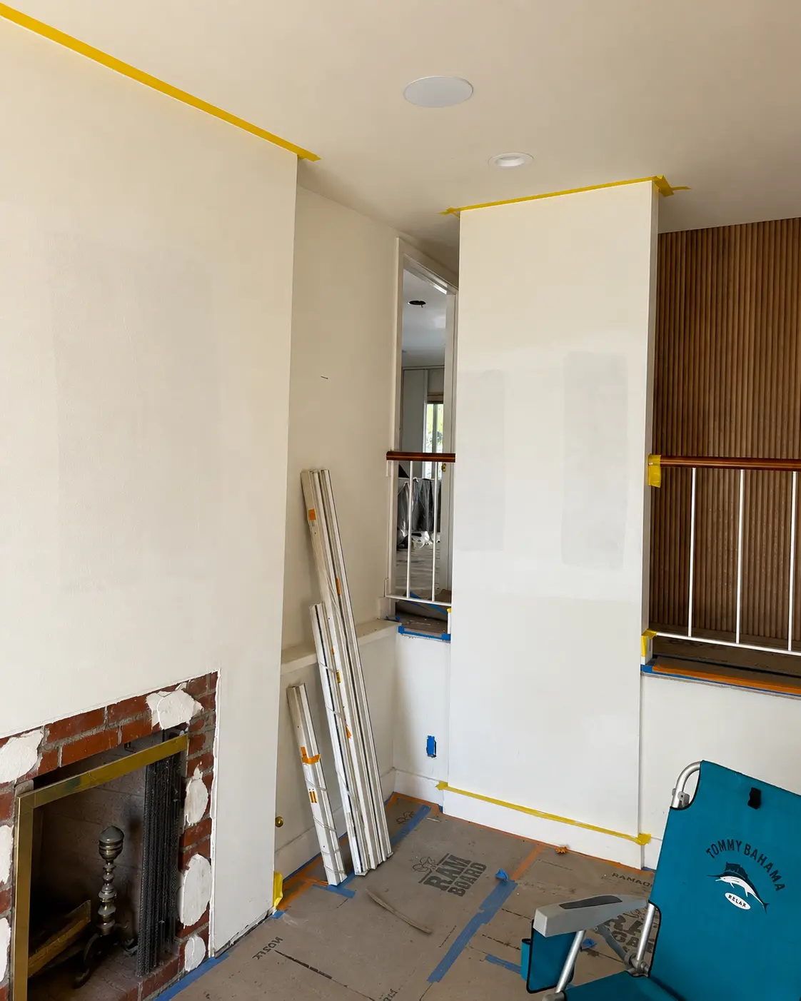 Surface preparation with primer before lime wash application in a living room renovation.