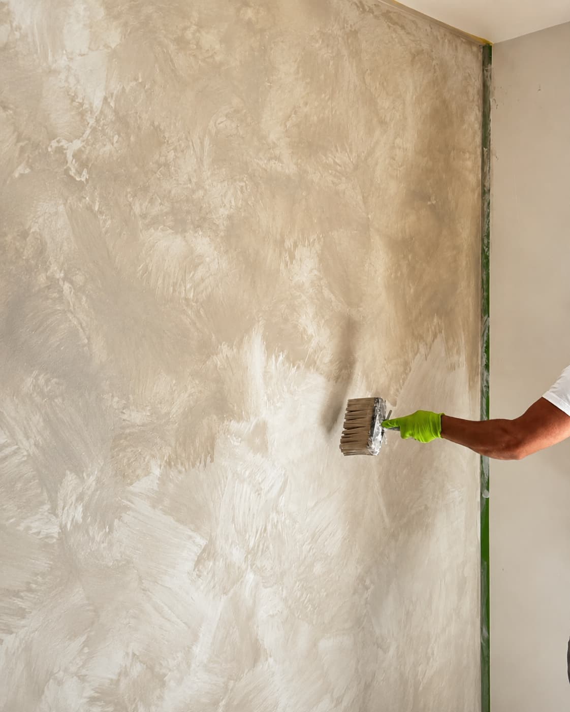 Bedroom accent wall during lime wash application, showing warm hand-applied movement.