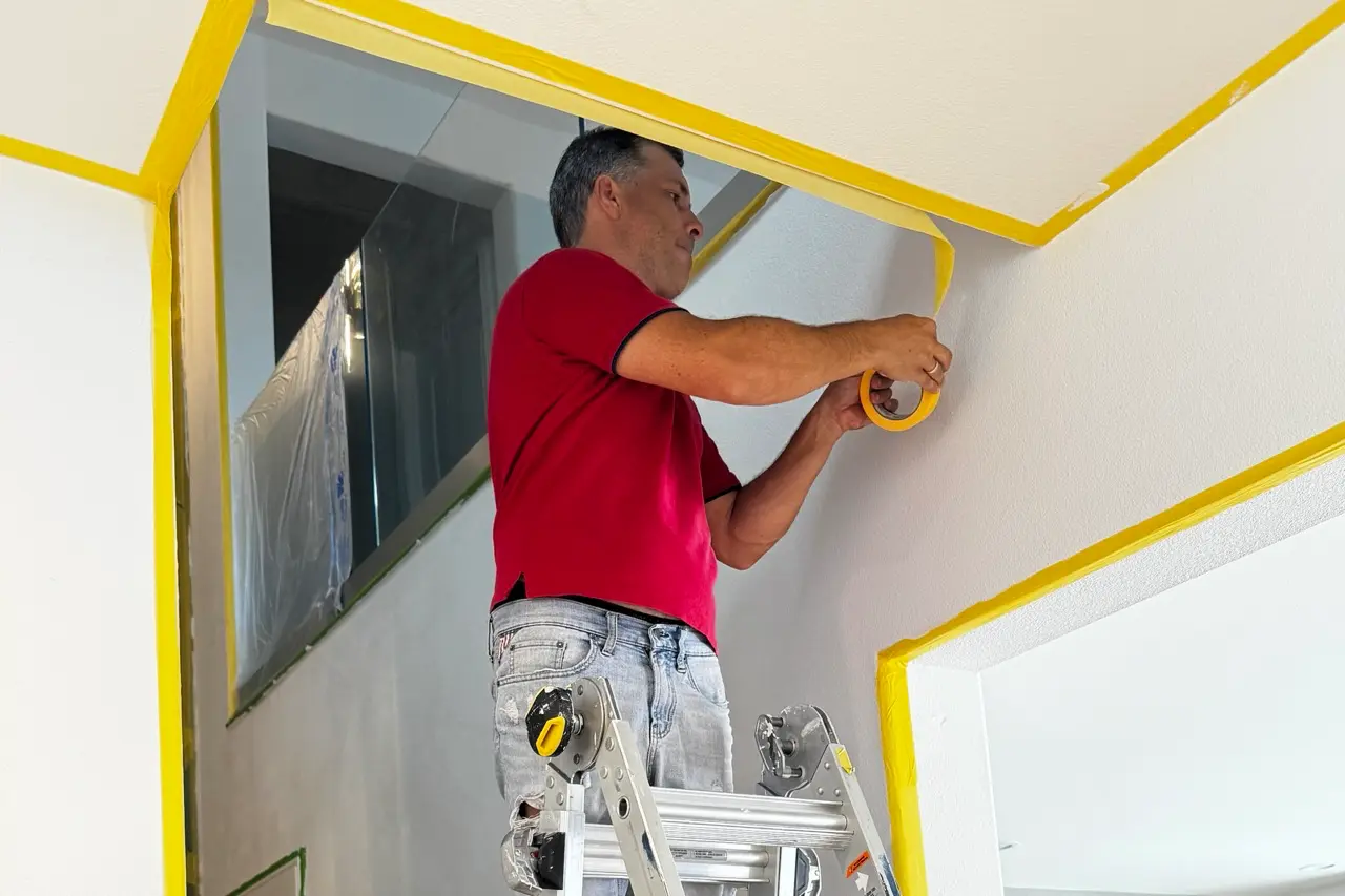 Adjacent stairwell surfaces and edges masked and protected before Venetian plaster application.