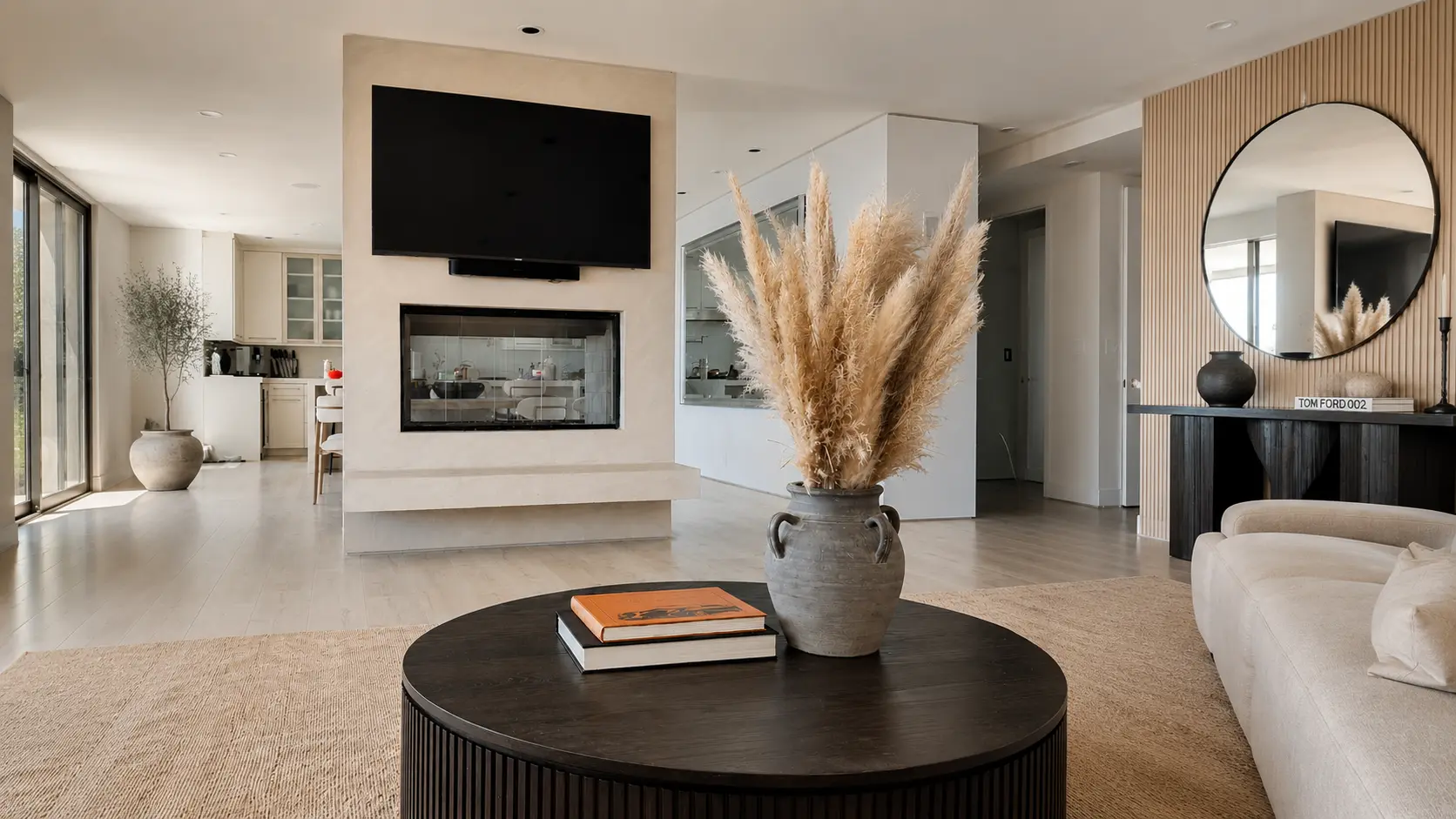 Open living room with a plaster fireplace wall and a fluted panel