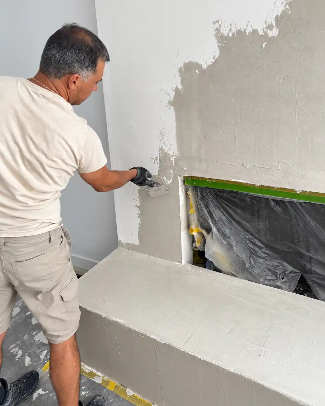 Specialist hand-applying Marmorino Tintoretto to the prepared fireplace surface.