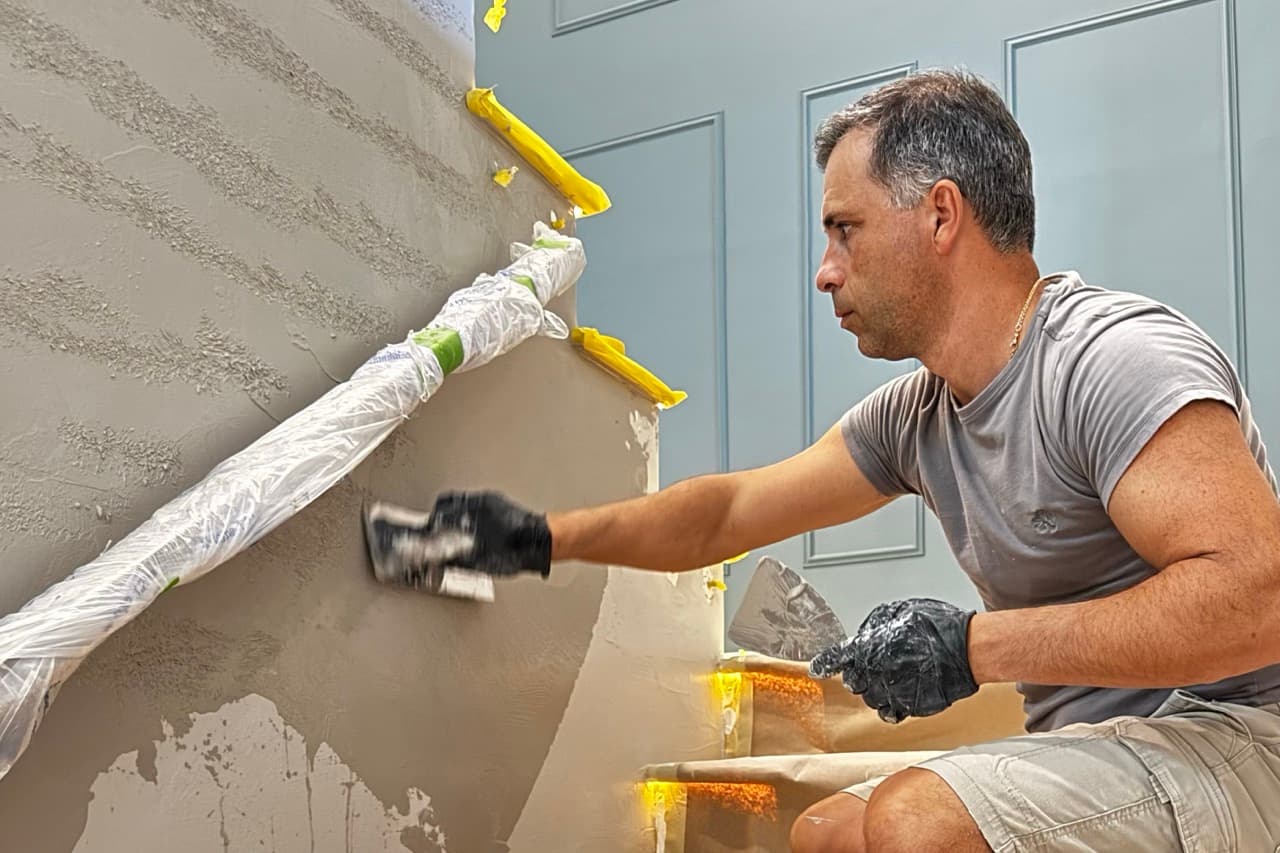 SBK finish specialist working the second coat of Venetian plaster and forming the travertine texture.