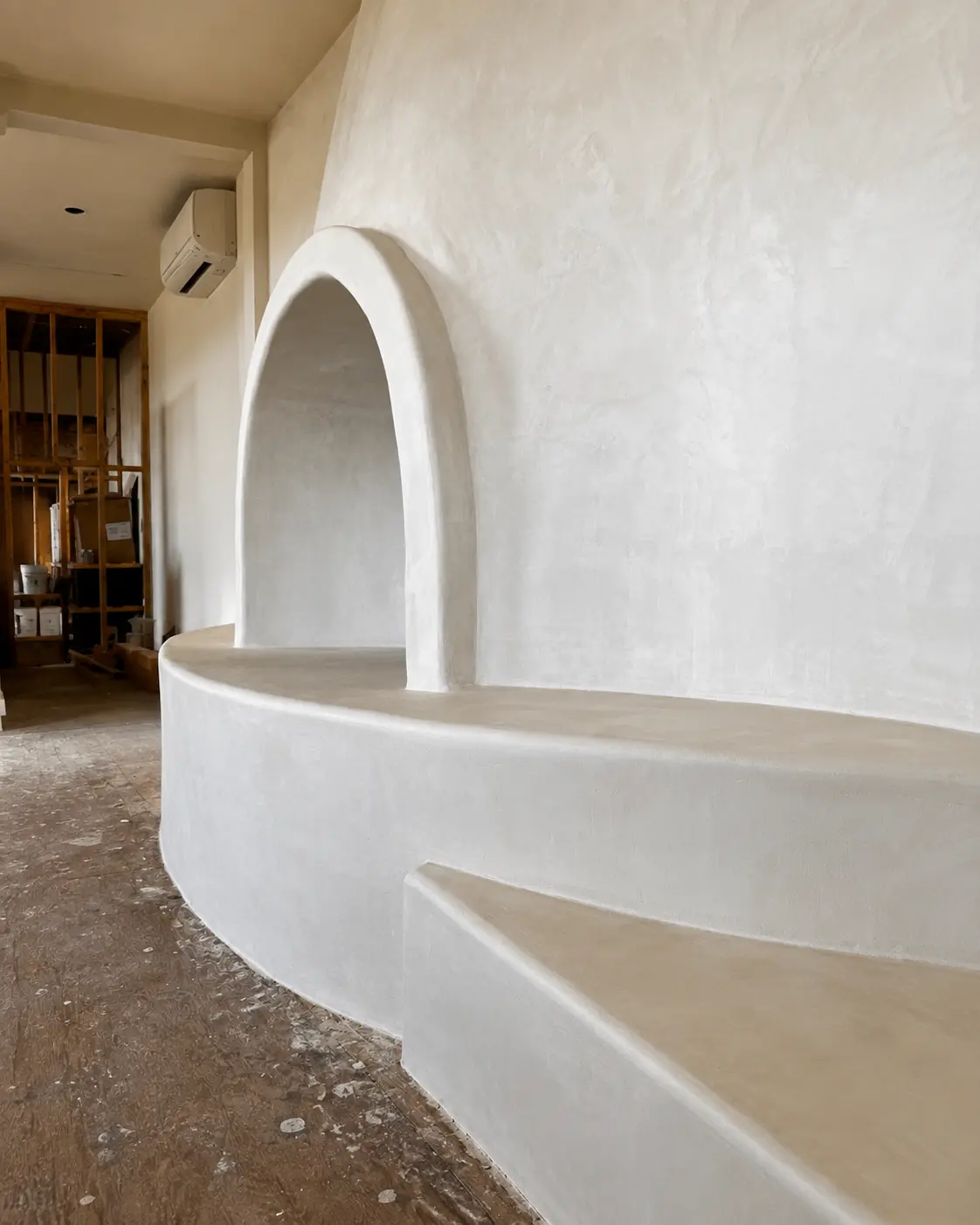 Close-up of the White Dove microcement surface showing fine troweled variation across the fireplace.