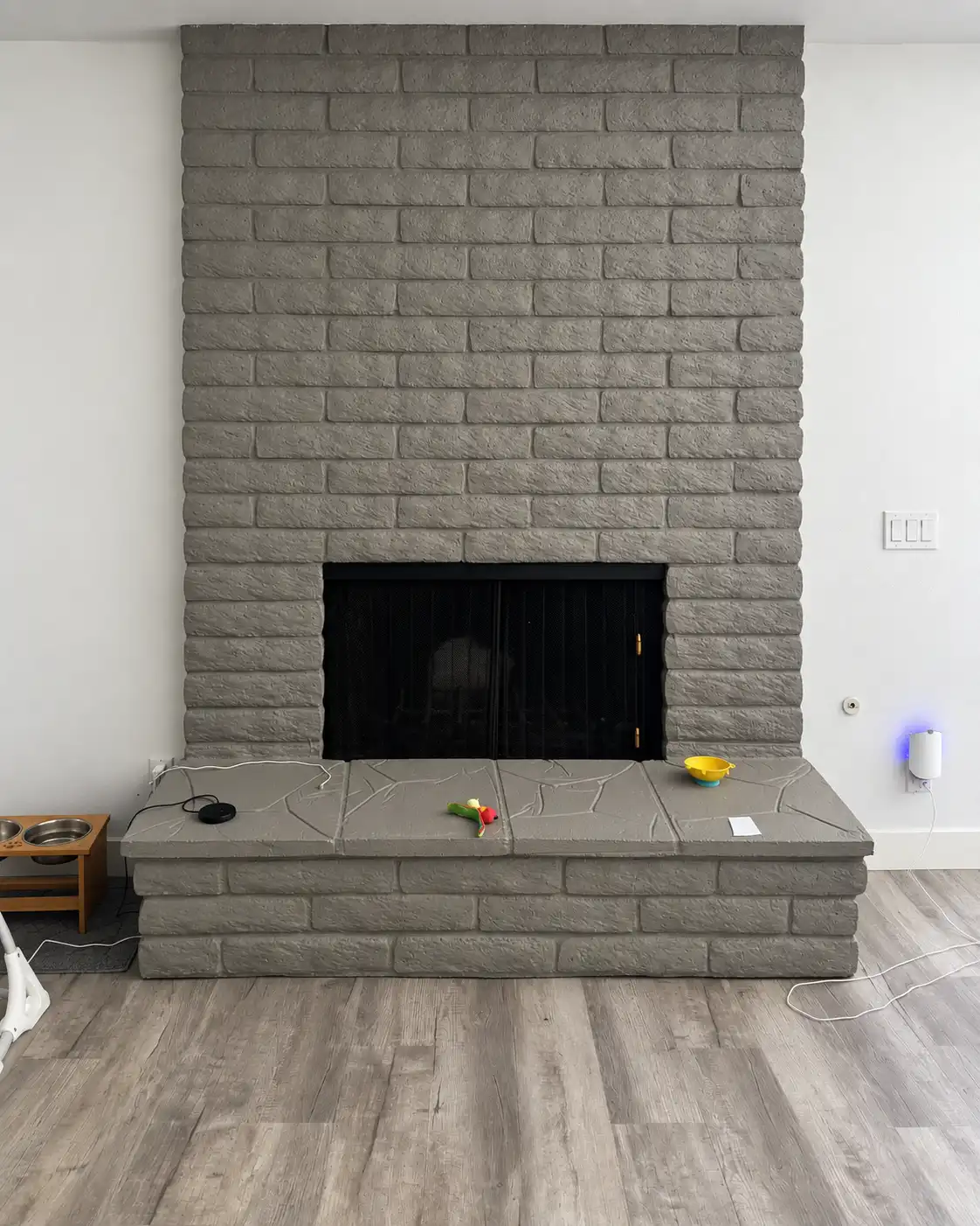 Painted brick fireplace with a raised hearth before the Marmorino Tintoretto renovation, in a Carlsbad living room.