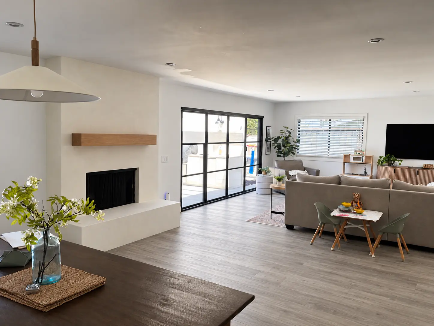 Completed Marmorino Tintoretto fireplace in MC-709 Pure White with a floating wood mantel, in a Carlsbad living room.