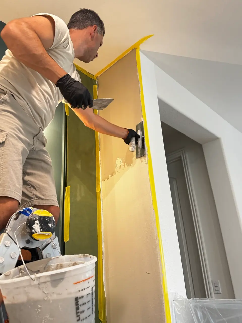 SBK finish specialist hand-applying the first coat of Venetian plaster to the stairwell wall.