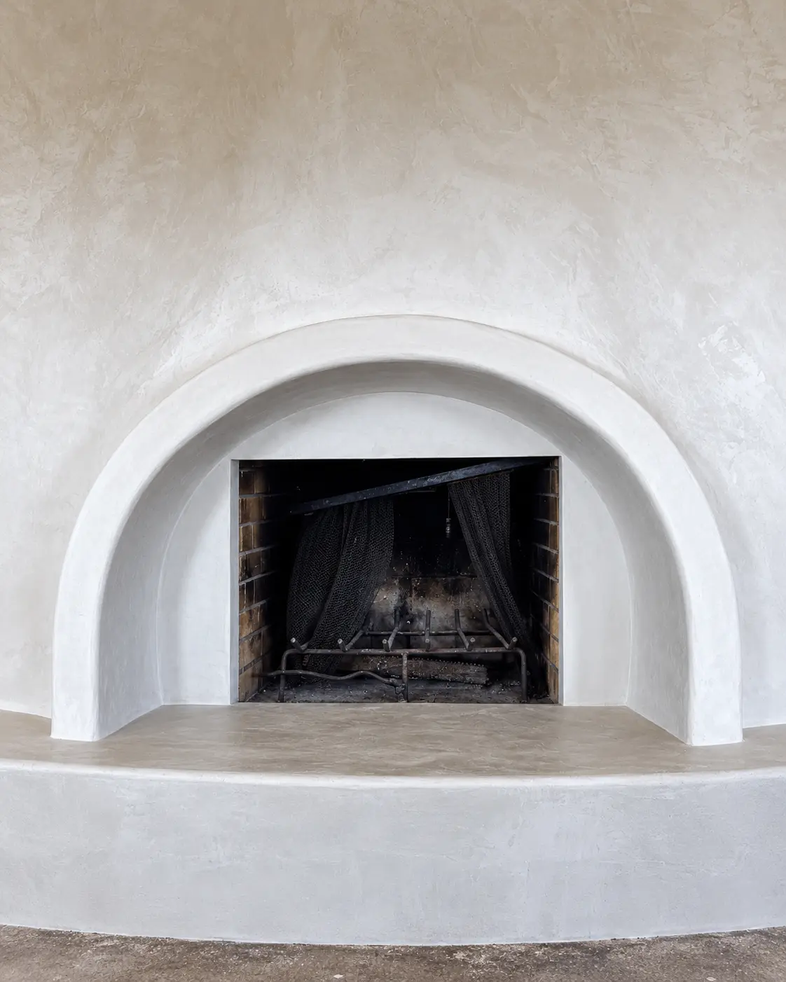Close detail of the finished White Dove microcement arch and hearth, a seamless hand-applied surface