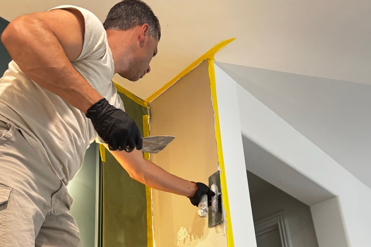 SBK finish specialist hand-applying the first coat of Venetian plaster to the stairwell wall.