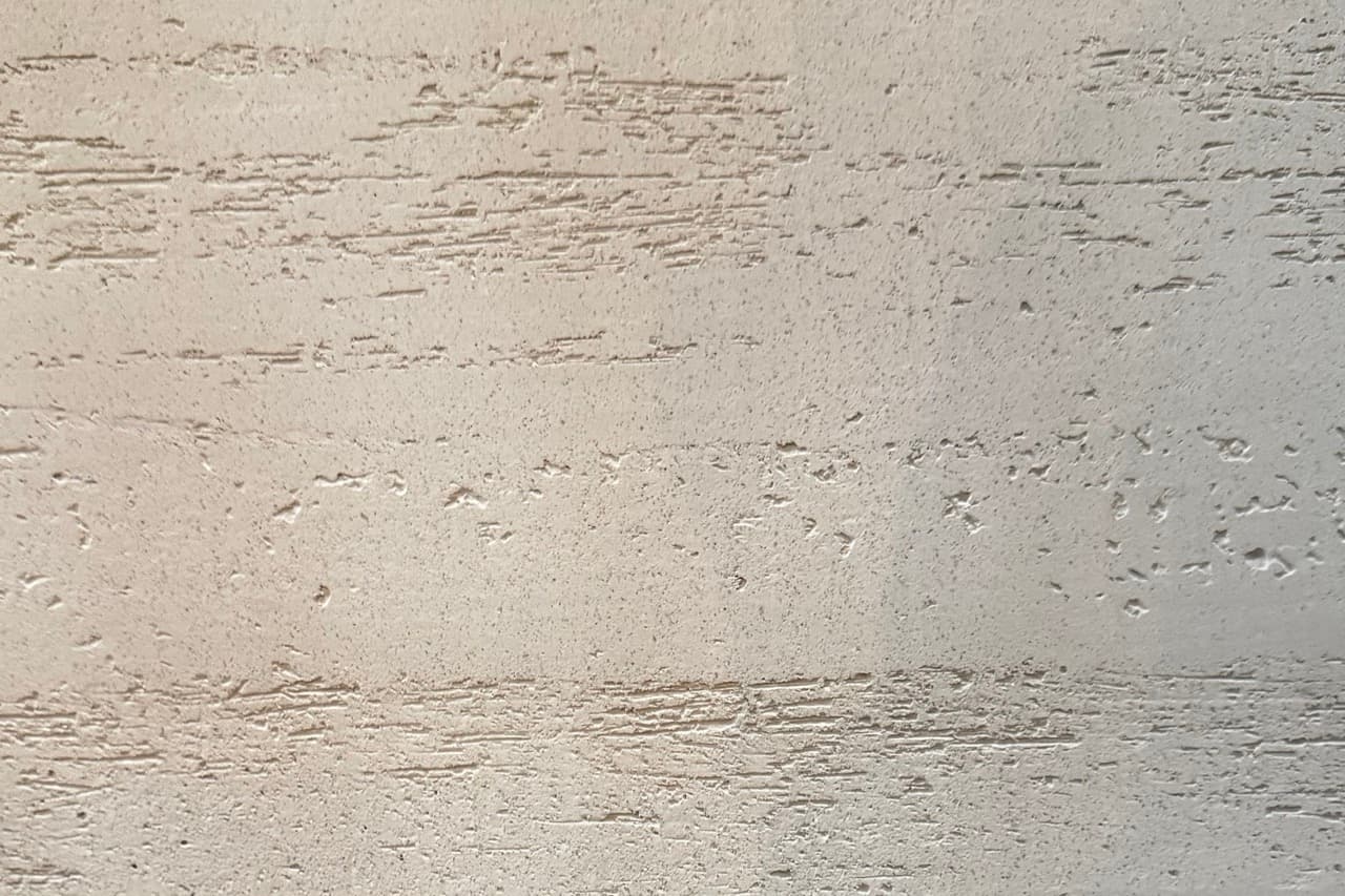 Close detail of the hand-applied Venetian plaster surface in a warm coffee travertine tone.