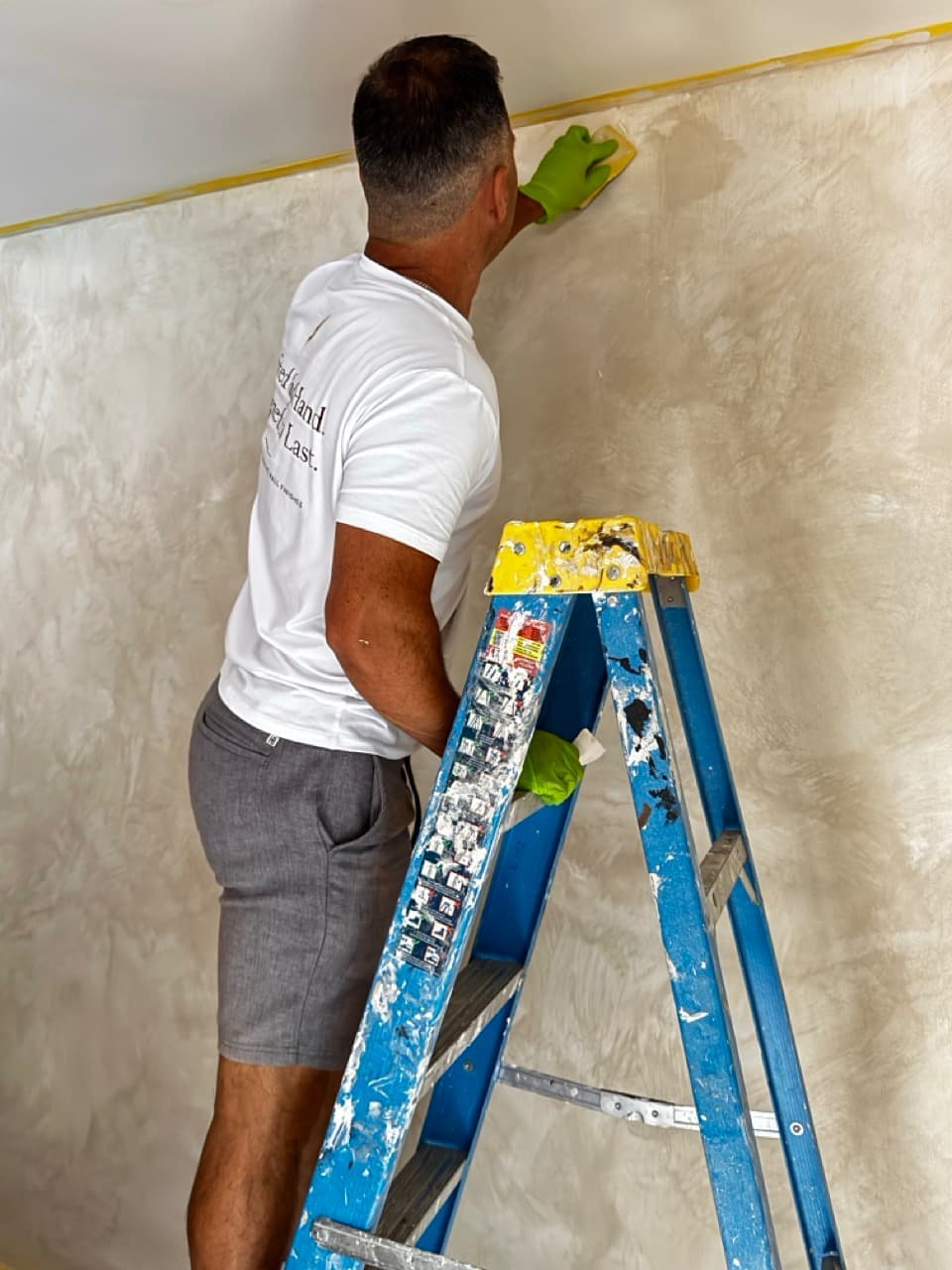First coat of lime wash developing soft movement across a living room fireplace wall.
